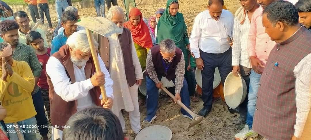 Villagers and organisation members digging to restore a dried pond